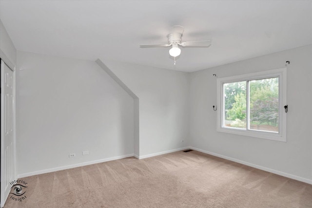 bonus room with light carpet and ceiling fan