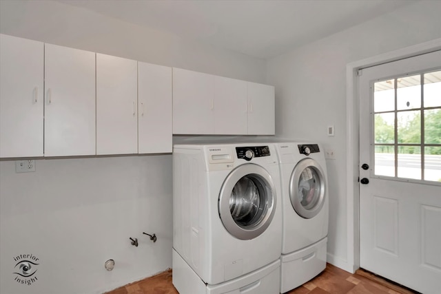 washroom featuring cabinets and washing machine and clothes dryer