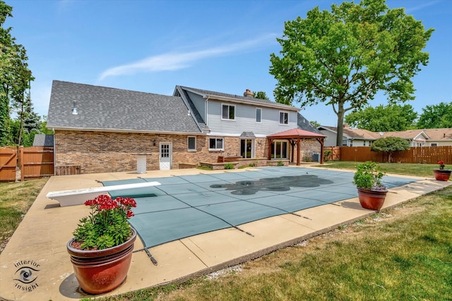 view of swimming pool featuring a gazebo, a patio area, a diving board, and a yard