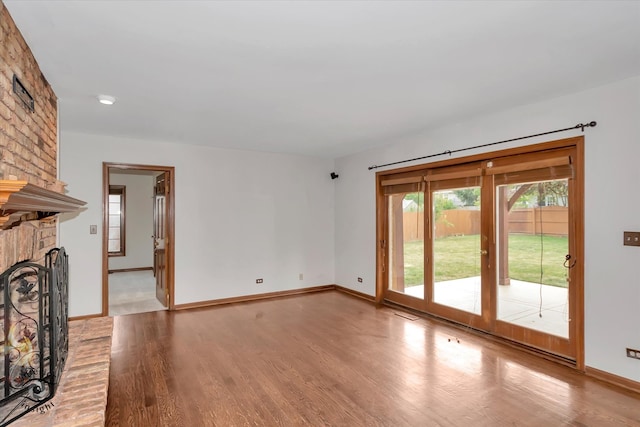 unfurnished living room with light hardwood / wood-style floors and a brick fireplace