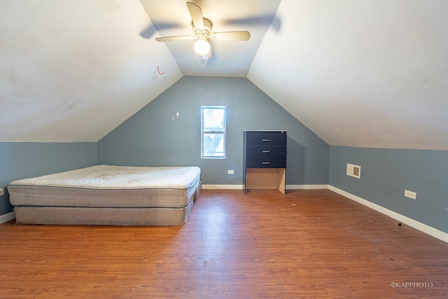 unfurnished bedroom with ceiling fan, wood-type flooring, and lofted ceiling