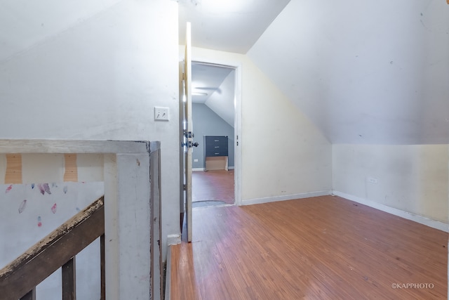 additional living space with hardwood / wood-style flooring and lofted ceiling