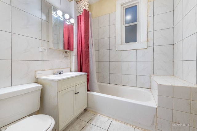 full bathroom featuring vanity, tile patterned floors, shower / bath combination with curtain, toilet, and tile walls