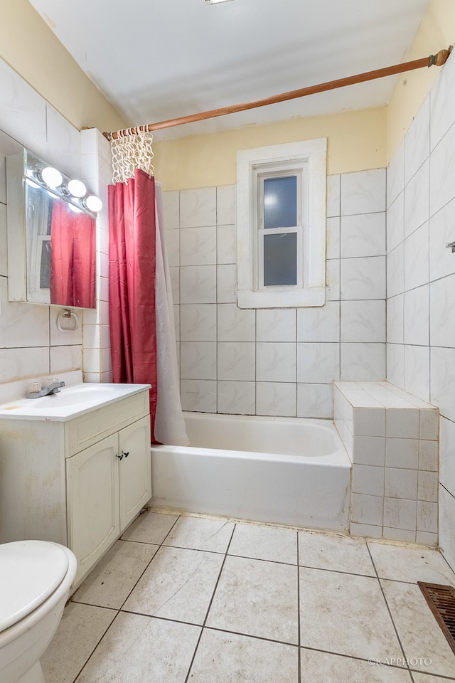 full bathroom with shower / tub combo, vanity, tile walls, tile patterned flooring, and toilet