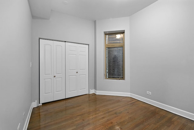 unfurnished bedroom featuring dark hardwood / wood-style flooring and a closet