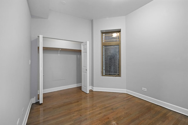 unfurnished bedroom with dark hardwood / wood-style flooring and a closet