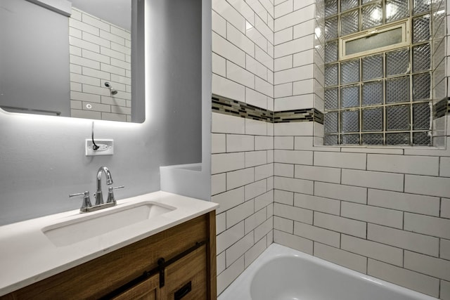 bathroom featuring vanity and tiled shower / bath