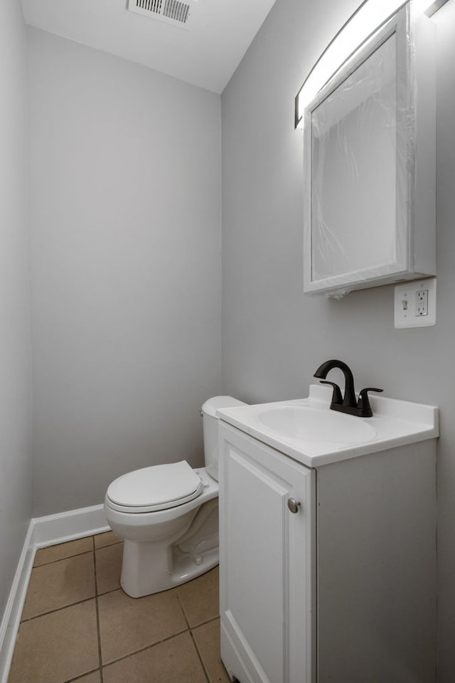 bathroom featuring tile patterned flooring, vanity, and toilet