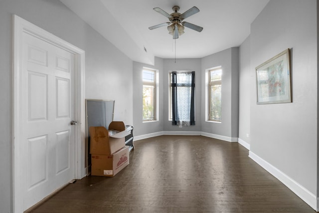 unfurnished living room with ceiling fan and dark wood-type flooring