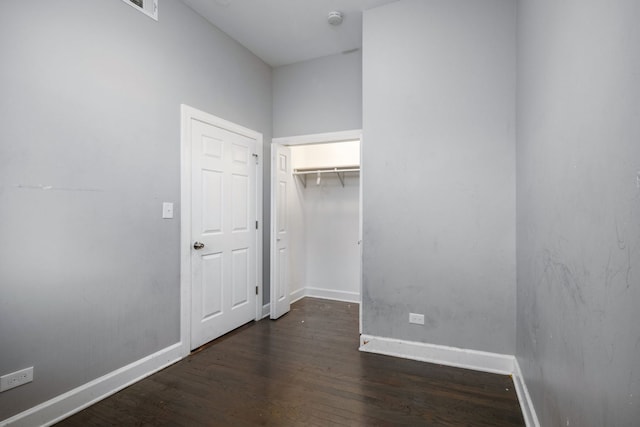 unfurnished bedroom with dark hardwood / wood-style flooring and a closet