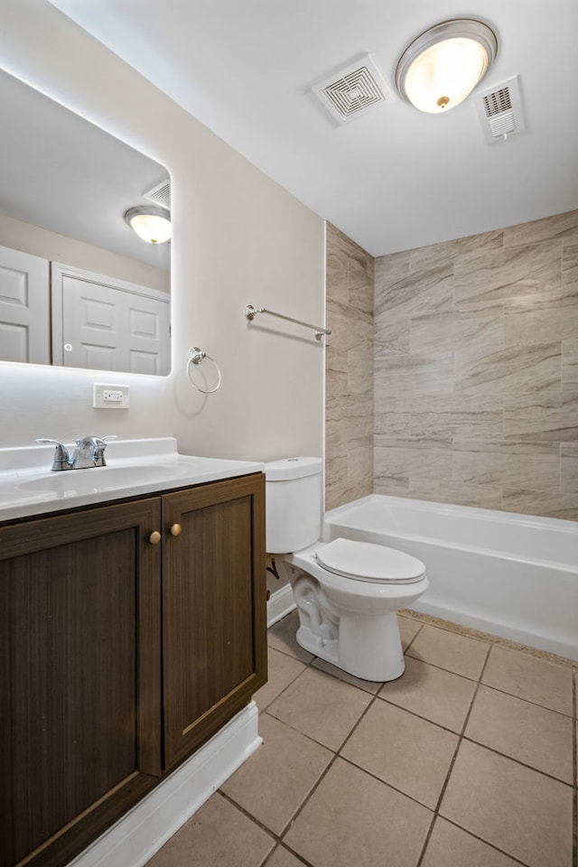 full bathroom with tile patterned floors, tiled shower / bath, vanity, and toilet