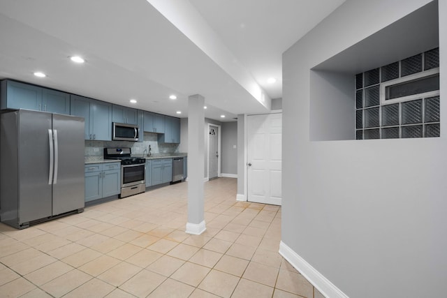 kitchen featuring blue cabinets, sink, tasteful backsplash, light tile patterned flooring, and stainless steel appliances