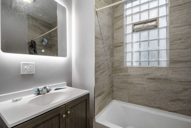 bathroom featuring vanity, a wealth of natural light, and tiled shower / bath combo