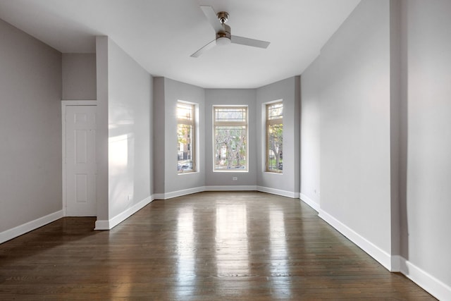 spare room with dark hardwood / wood-style flooring and ceiling fan