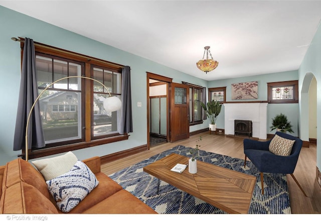 living room featuring hardwood / wood-style flooring, a brick fireplace, and a wealth of natural light