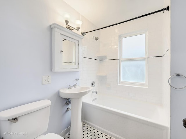 bathroom featuring tiled shower / bath combo and toilet