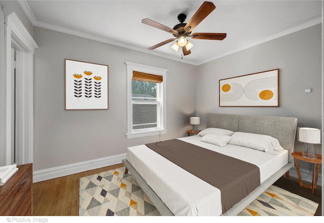 bedroom featuring hardwood / wood-style floors, ceiling fan, and crown molding