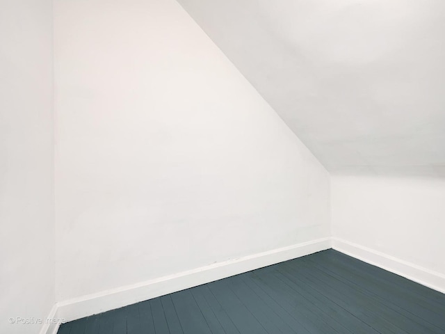 additional living space with wood-type flooring and vaulted ceiling