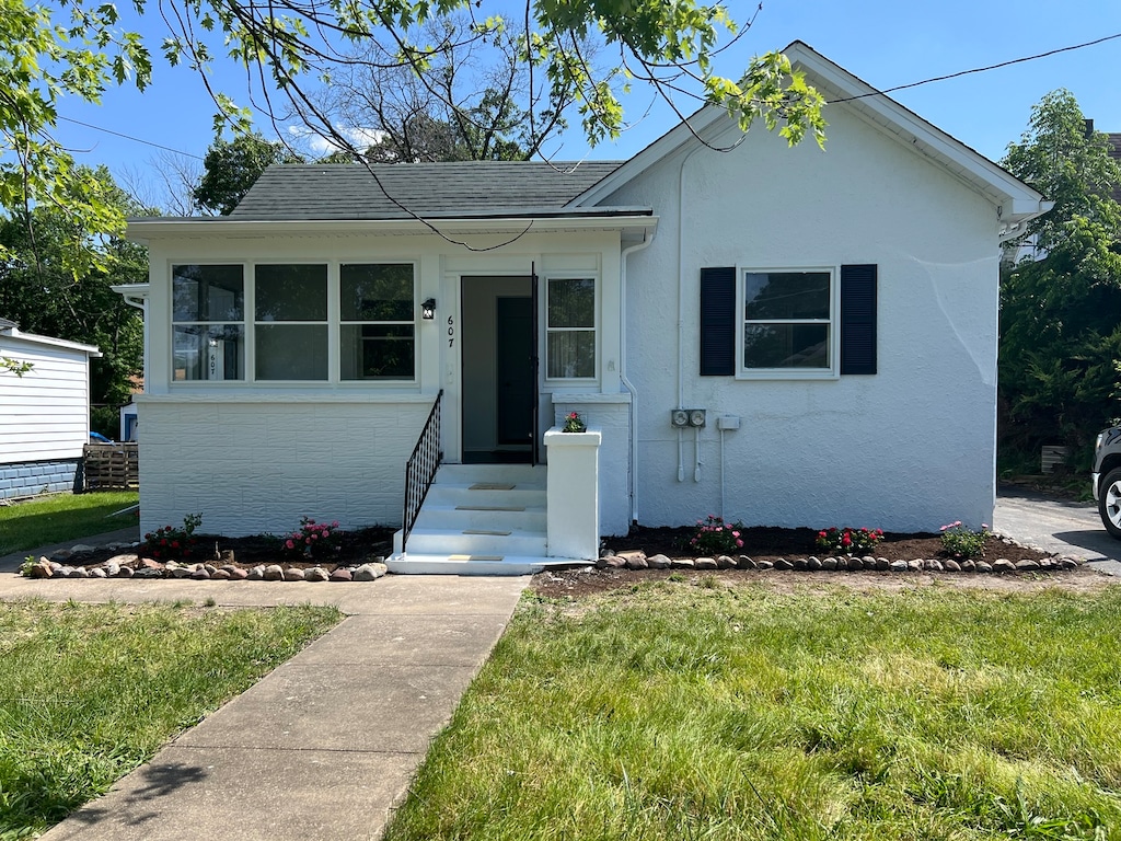 bungalow featuring a front lawn