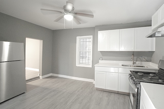 kitchen featuring white cabinetry, sink, ceiling fan, stainless steel appliances, and light hardwood / wood-style floors