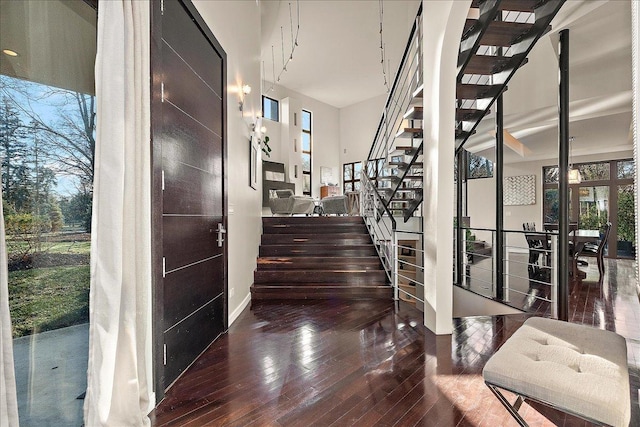 staircase with a high ceiling and hardwood / wood-style flooring