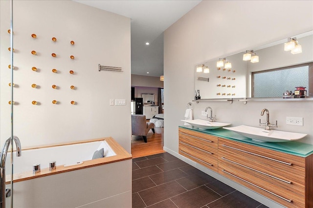 bathroom with a bathing tub, hardwood / wood-style floors, and vanity