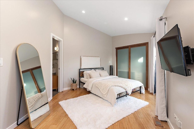 bedroom with light hardwood / wood-style flooring and vaulted ceiling