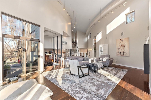 living room featuring dark hardwood / wood-style floors and a towering ceiling