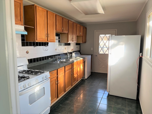 kitchen featuring sink, dark tile patterned floors, backsplash, crown molding, and white appliances