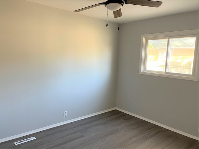 spare room featuring ceiling fan and dark wood-type flooring