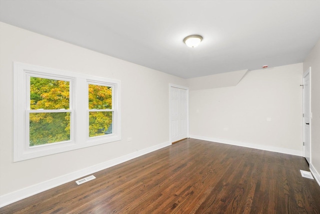 unfurnished room with dark wood-type flooring