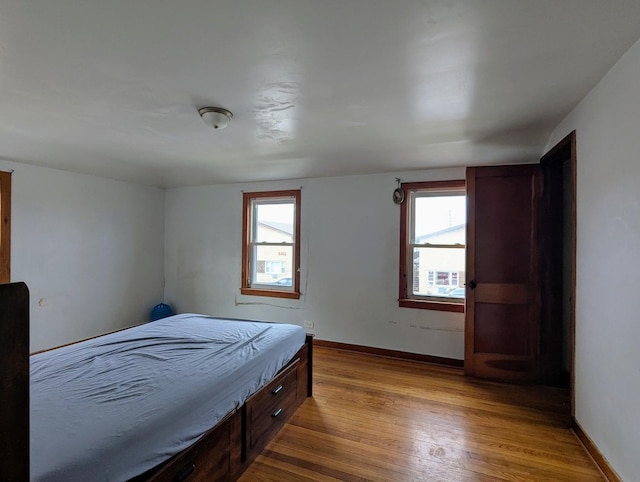 bedroom with multiple windows and light hardwood / wood-style floors