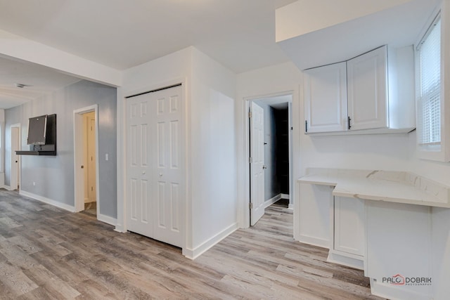 kitchen with light wood-type flooring and white cabinetry