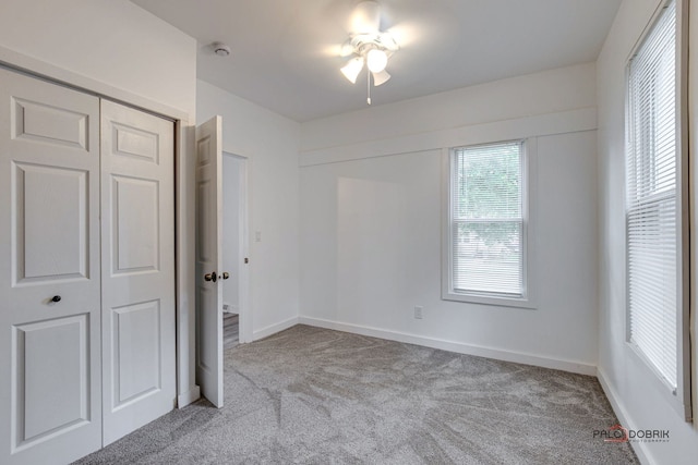 unfurnished bedroom featuring light carpet and a closet