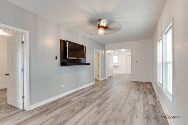 unfurnished living room featuring ceiling fan and light hardwood / wood-style floors