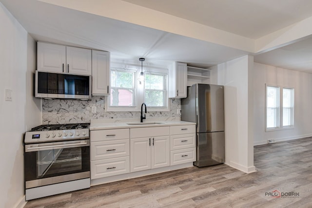 kitchen with backsplash, sink, stainless steel appliances, and a wealth of natural light