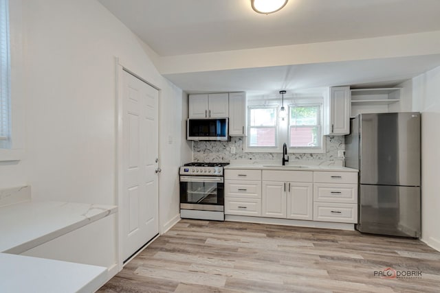 kitchen featuring backsplash, white cabinetry, sink, and stainless steel appliances