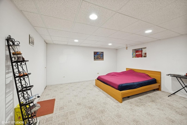 carpeted bedroom featuring a drop ceiling