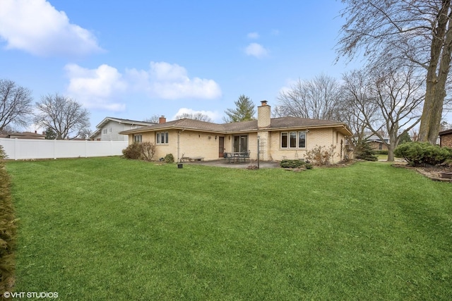 rear view of house featuring a yard and a patio