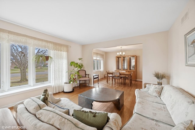 living room featuring light hardwood / wood-style floors and a notable chandelier