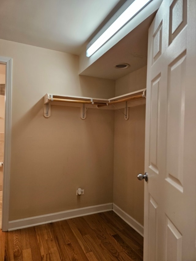 spacious closet with dark hardwood / wood-style flooring