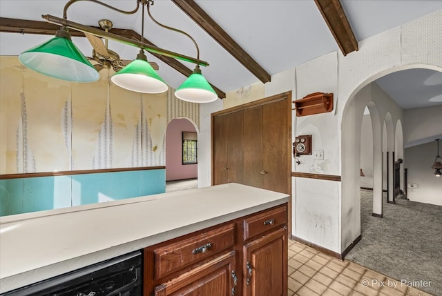 kitchen featuring pendant lighting, lofted ceiling with beams, and light colored carpet