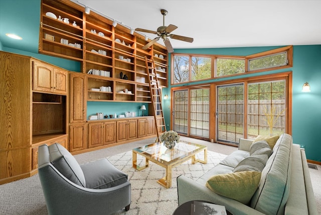 carpeted living room with ceiling fan and lofted ceiling