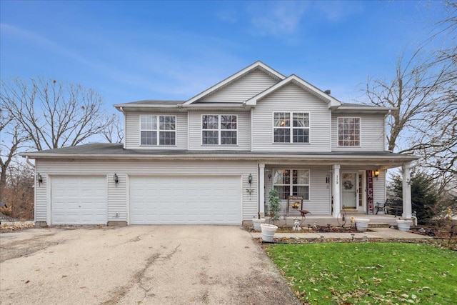 view of property with a garage and covered porch