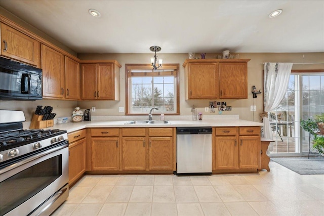 kitchen featuring a chandelier, sink, stainless steel appliances, and decorative light fixtures