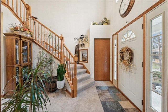 foyer with a high ceiling and light tile patterned floors