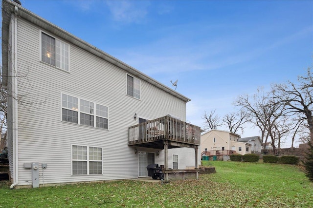 rear view of property with a wooden deck and a lawn