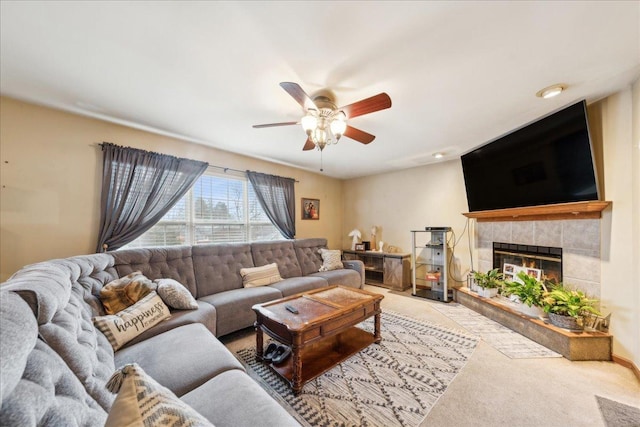 living room featuring ceiling fan, light carpet, and a tiled fireplace