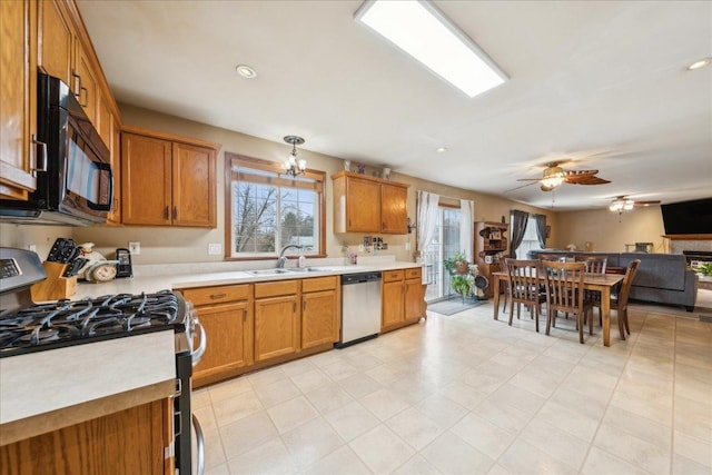 kitchen featuring appliances with stainless steel finishes, ceiling fan with notable chandelier, and sink