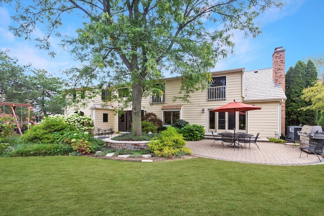 rear view of house with a yard and a patio